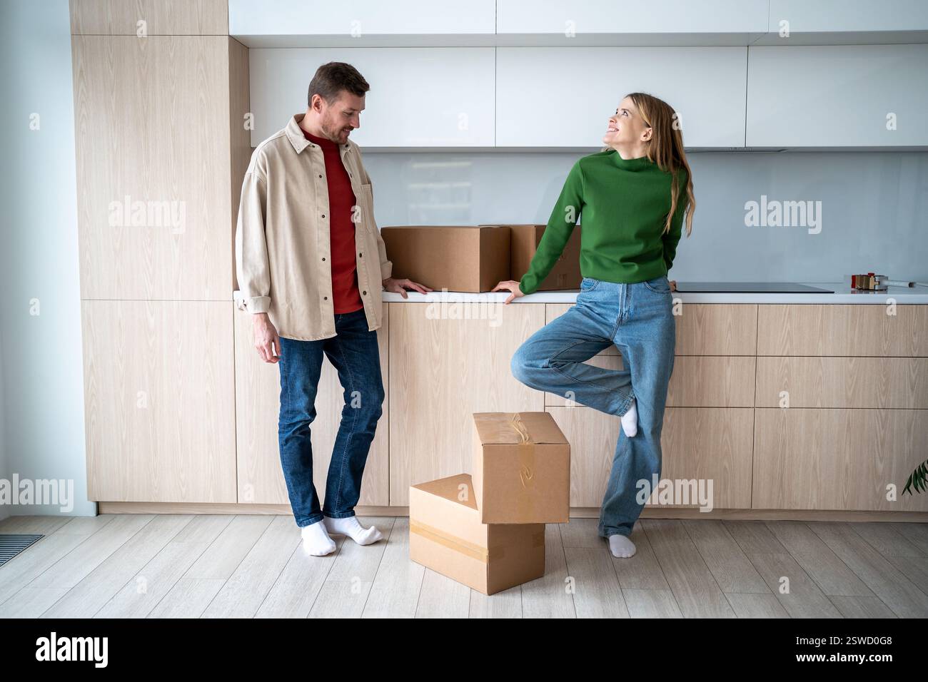 Happy woman dreaming looks stands with man near cardboard boxes in ...
