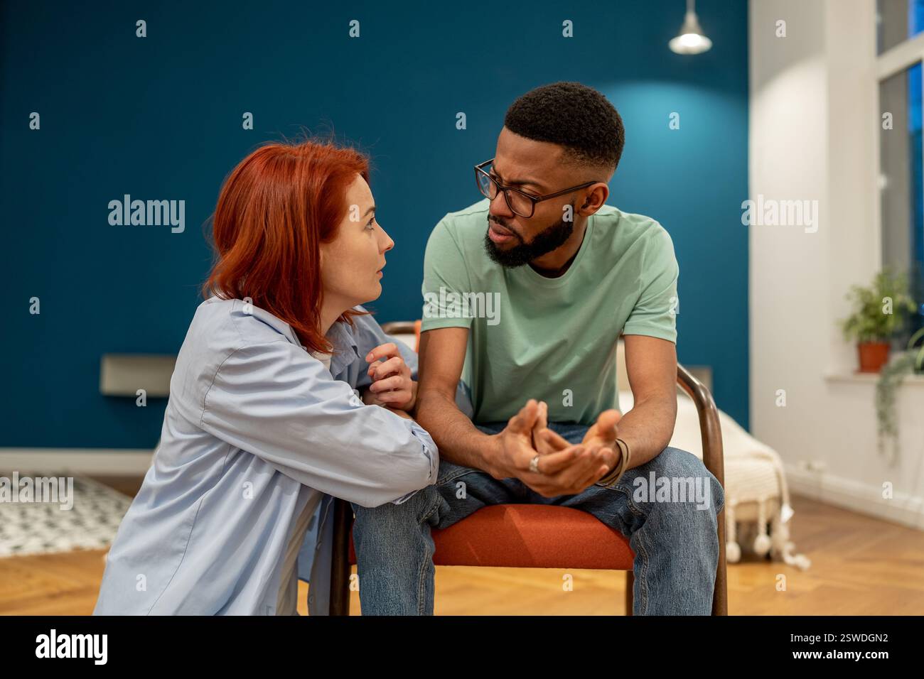 Unhappy serious interracial couple young man and woman talking about ...