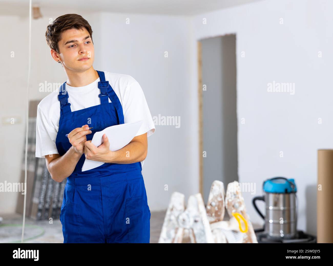 Young foreman making task list during works in building under construction Stock Photo