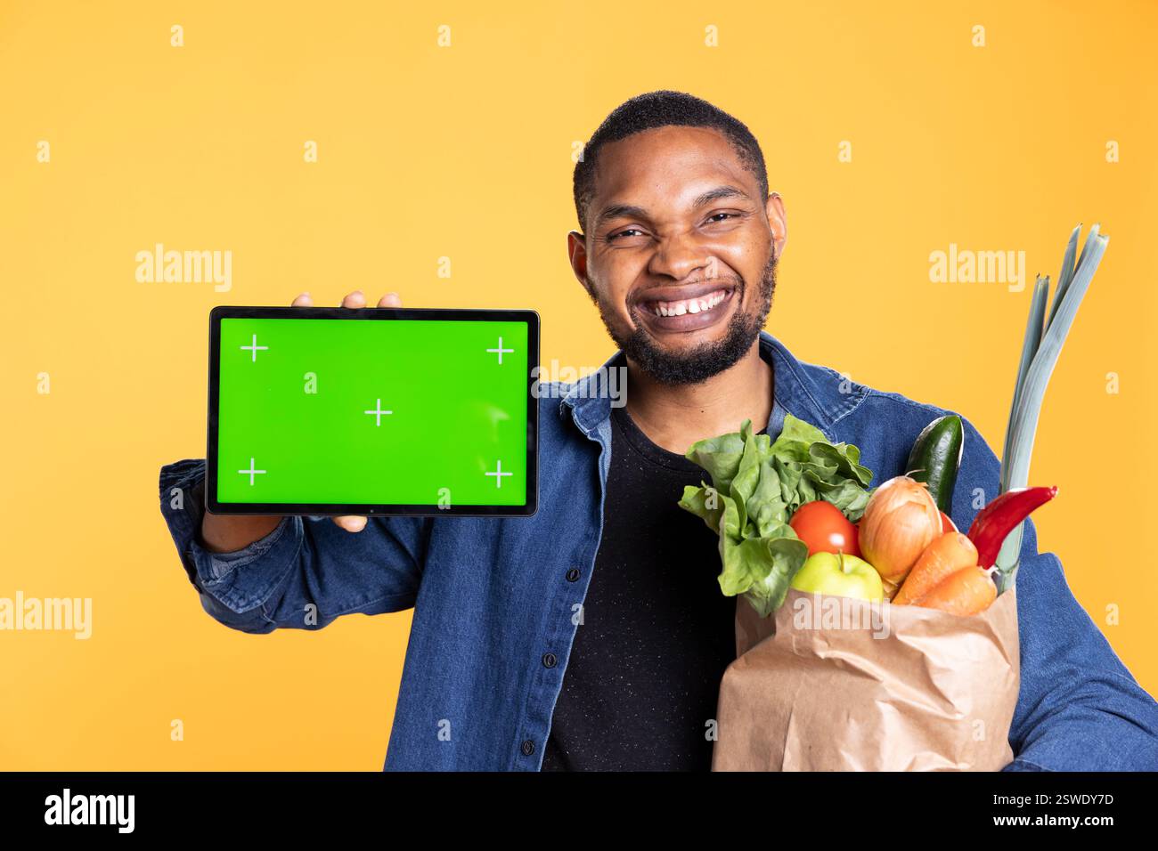 African american careless happy model holds tablet with greenscreen ...