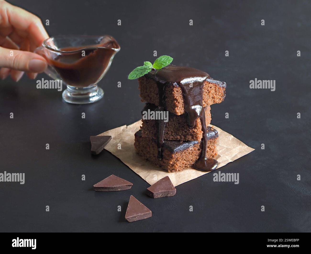 Slices of delicious brownie in a stack and poured with chocolate Stock Photo