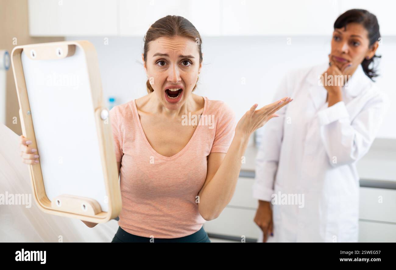 Dissatisfied woman checking result after cosmetology procedure Stock Photo