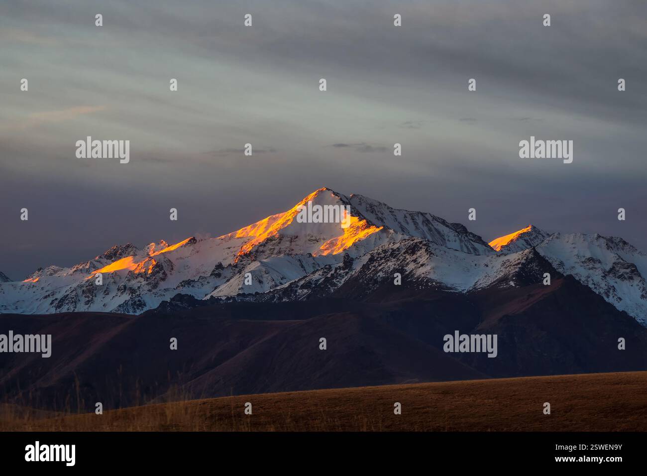 The first rays of the dawn sun on the snowy mountain peaks. Atmo Stock ...