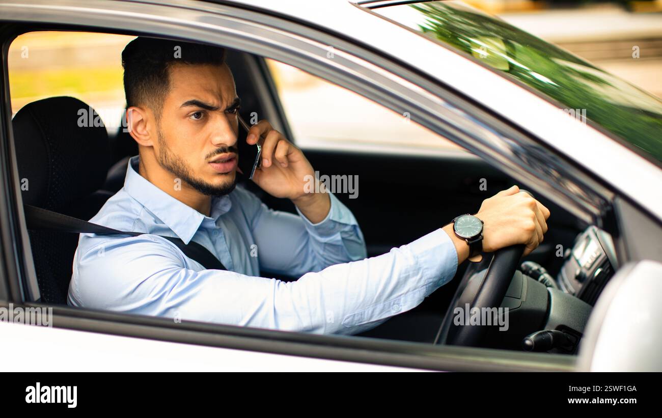 Angry arabic guy manager fighting on phone while driving auto Stock Photo
