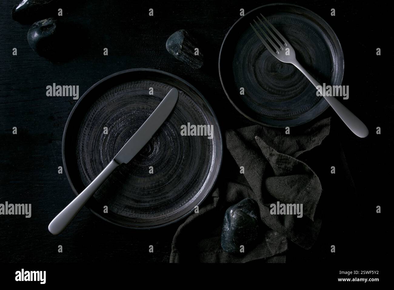 Empty black ceramic plates with black stones Stock Photo