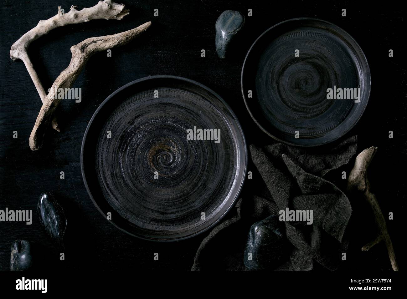 Empty black ceramic plates with black stones Stock Photo
