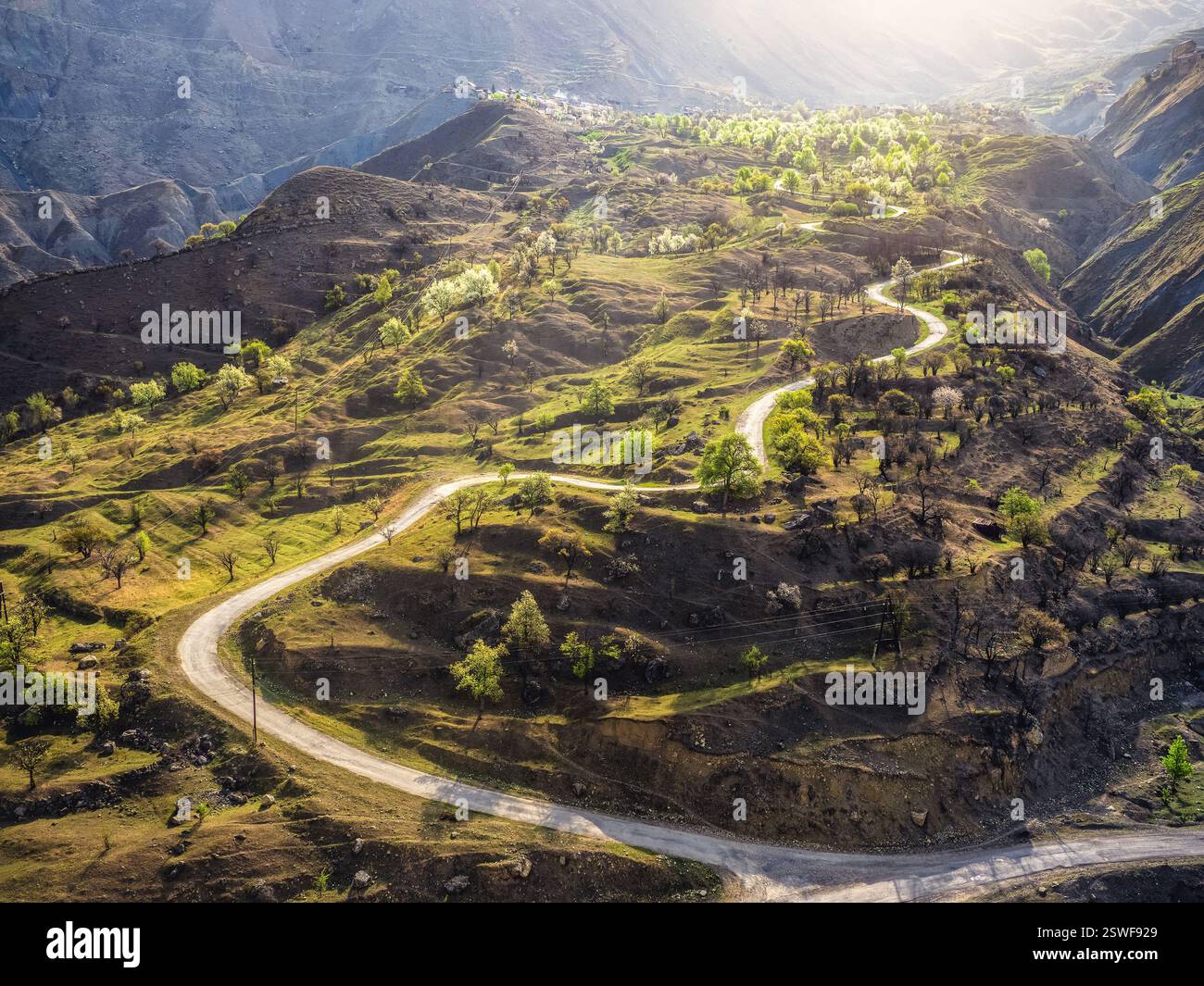 Mountain serpentine in the dawn sunlight. A narrow dirt mountain Stock Photo