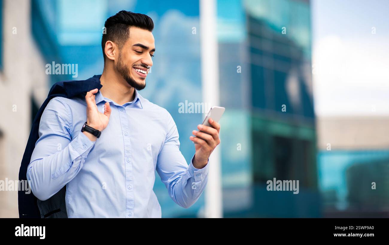 Middle-eastern young entrepreneur checking emails on smartphone Stock Photo