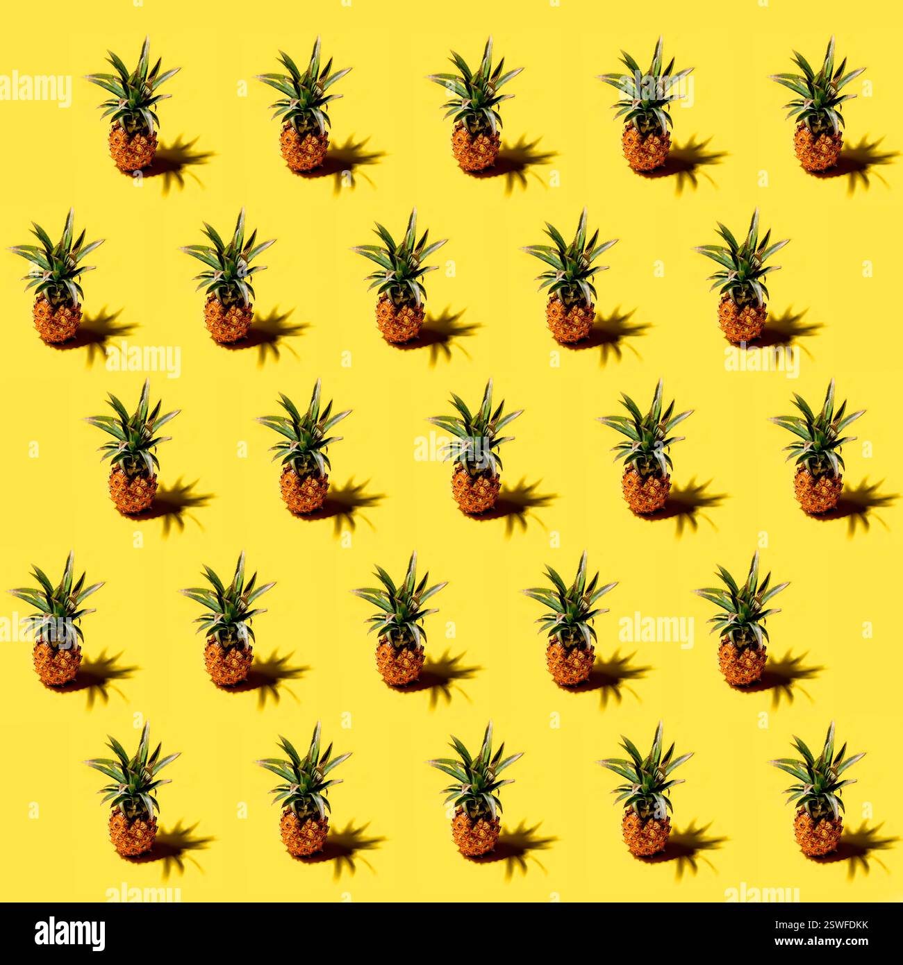 Many pineapples on a solid yellow background pattern Stock Photo