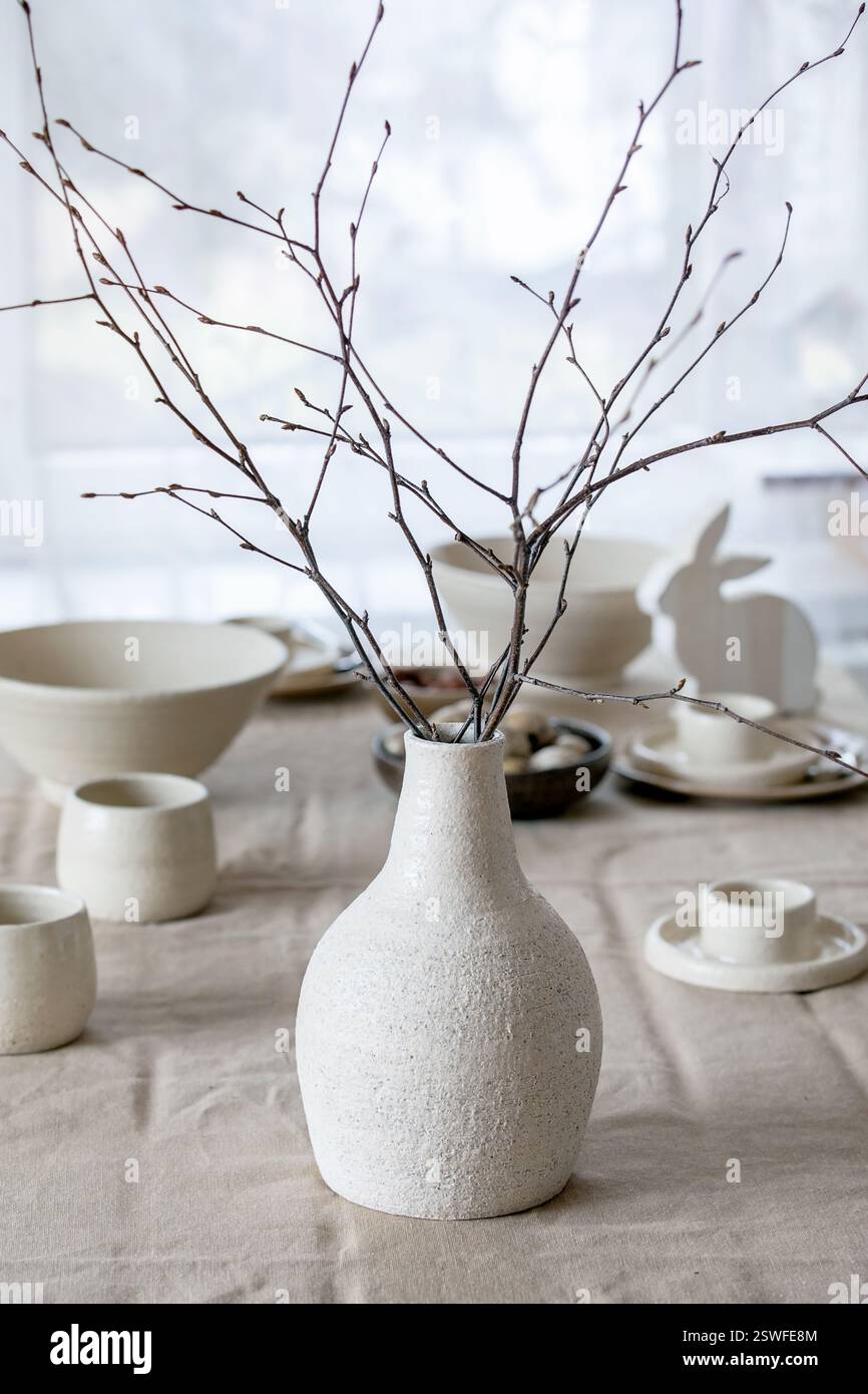 Spring birch branches in white ceramic vase Stock Photo
