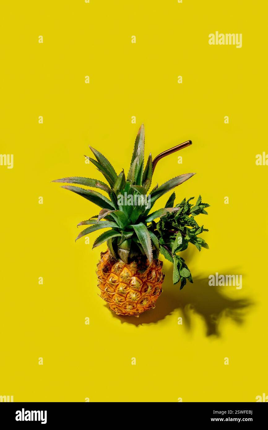 Mini pineappl on a solid yellow background Stock Photo
