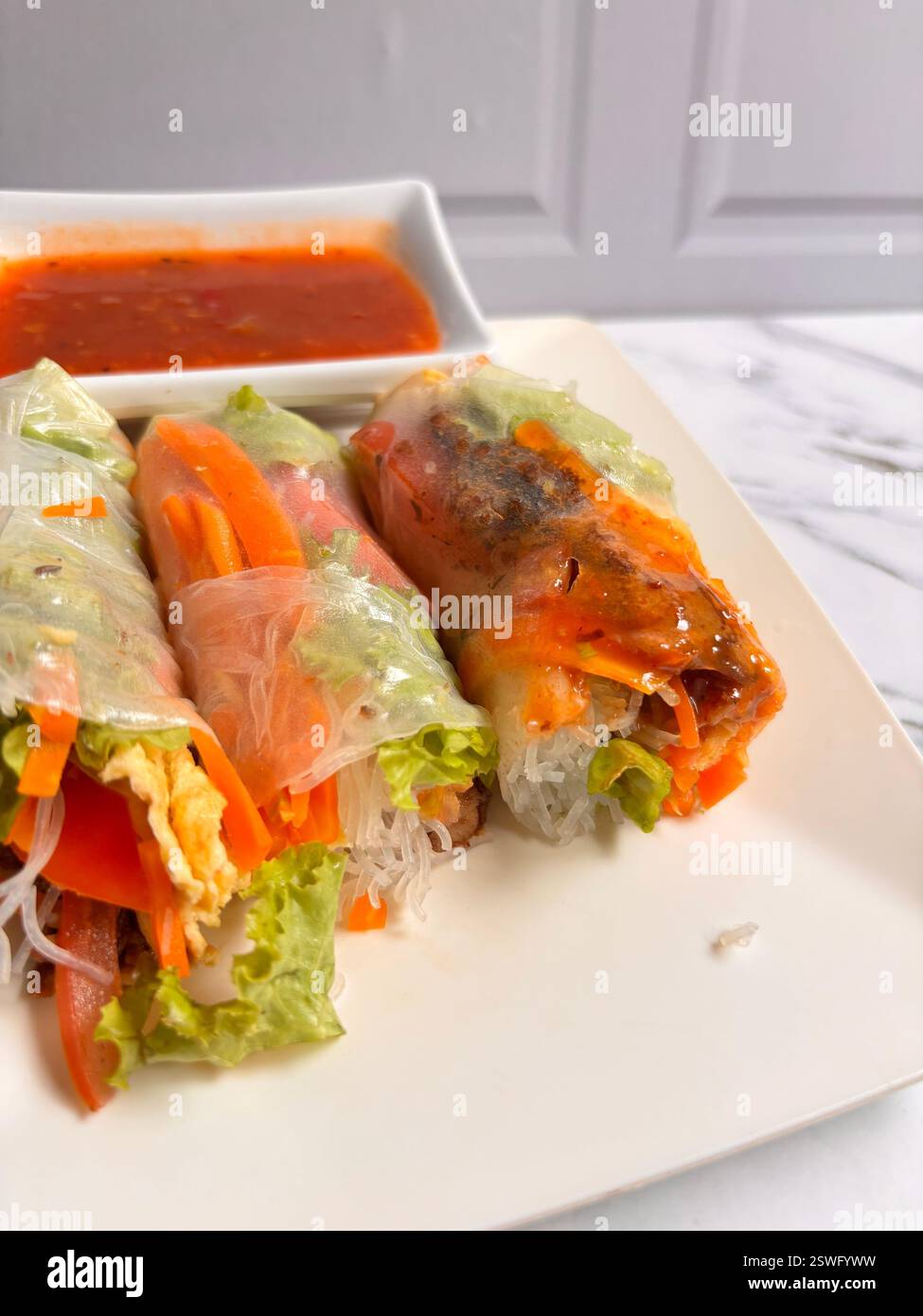 These vibrant salad rolls are a fresh and healthy twist on traditional salads, wrapped in delicate rice paper for a satisfying bite. Packed with crunc - Smartphone Captured Stock Image
