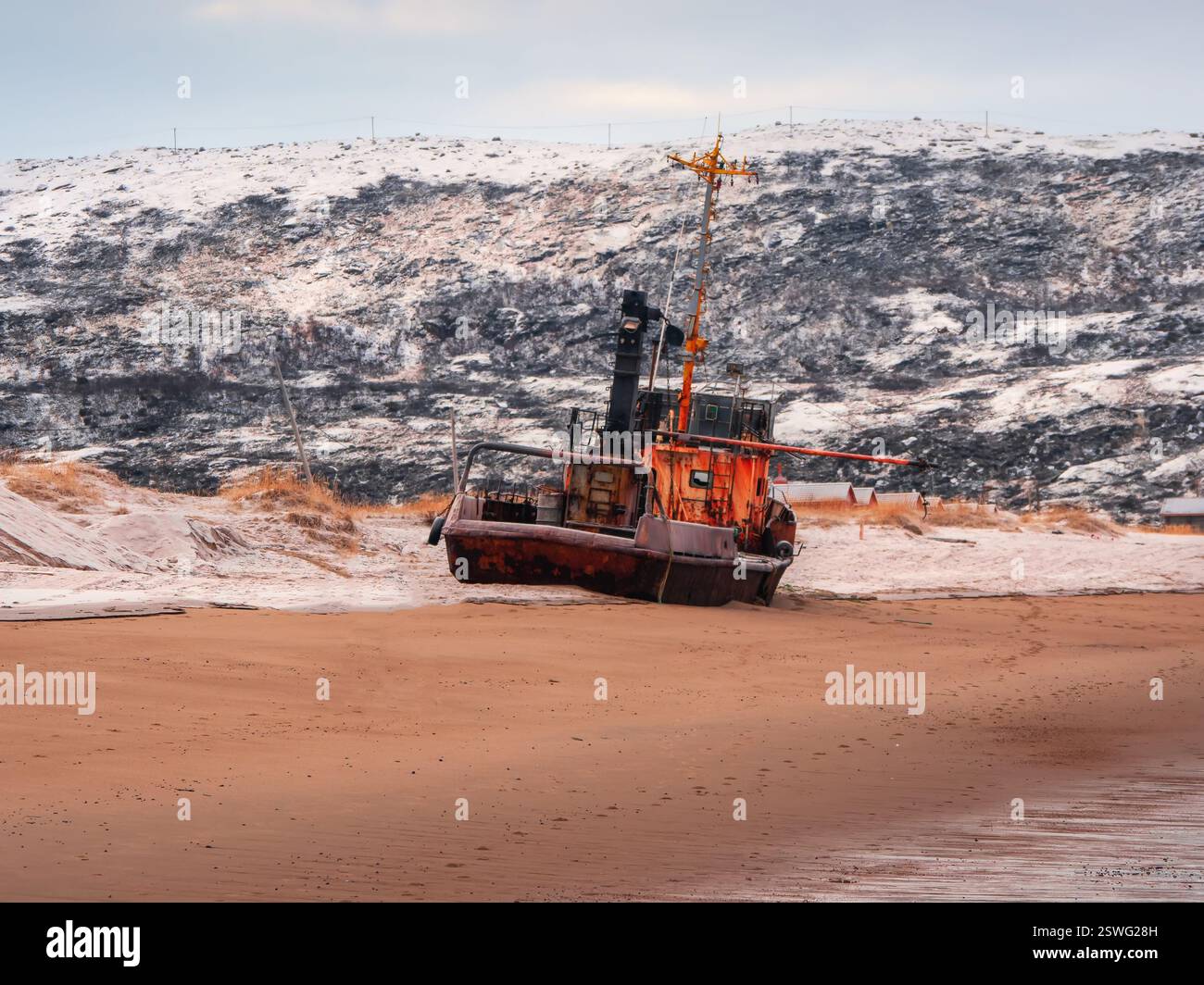 An old rusty fishing boat abandoned by a storm on the shore. Graveyard ...