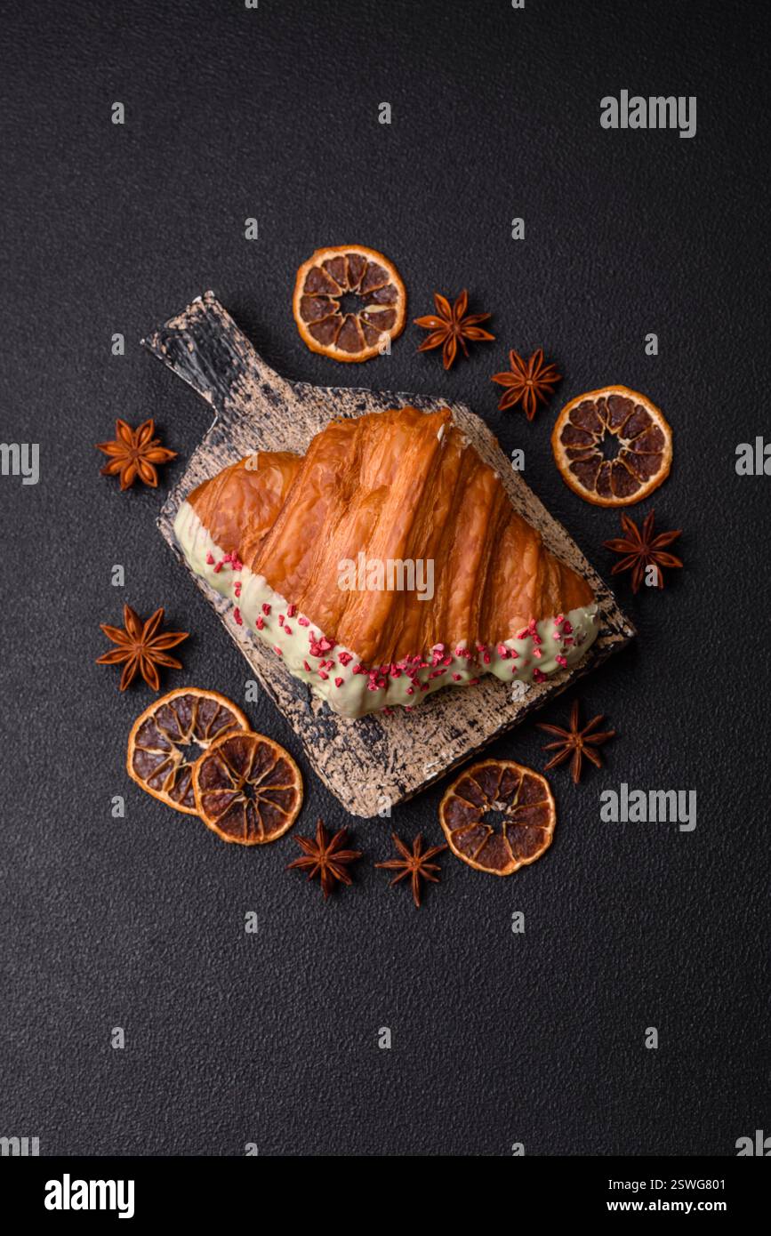 Crispy sweet red croissant with pistachio, raspberry and strawberry Stock Photo