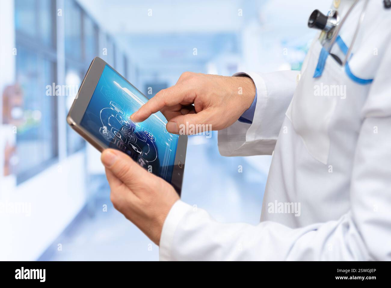 A healthcare professional examines information on a digital tablet in a bright, high-tech medical facility, focusing on patient data analysis. Stock Photo