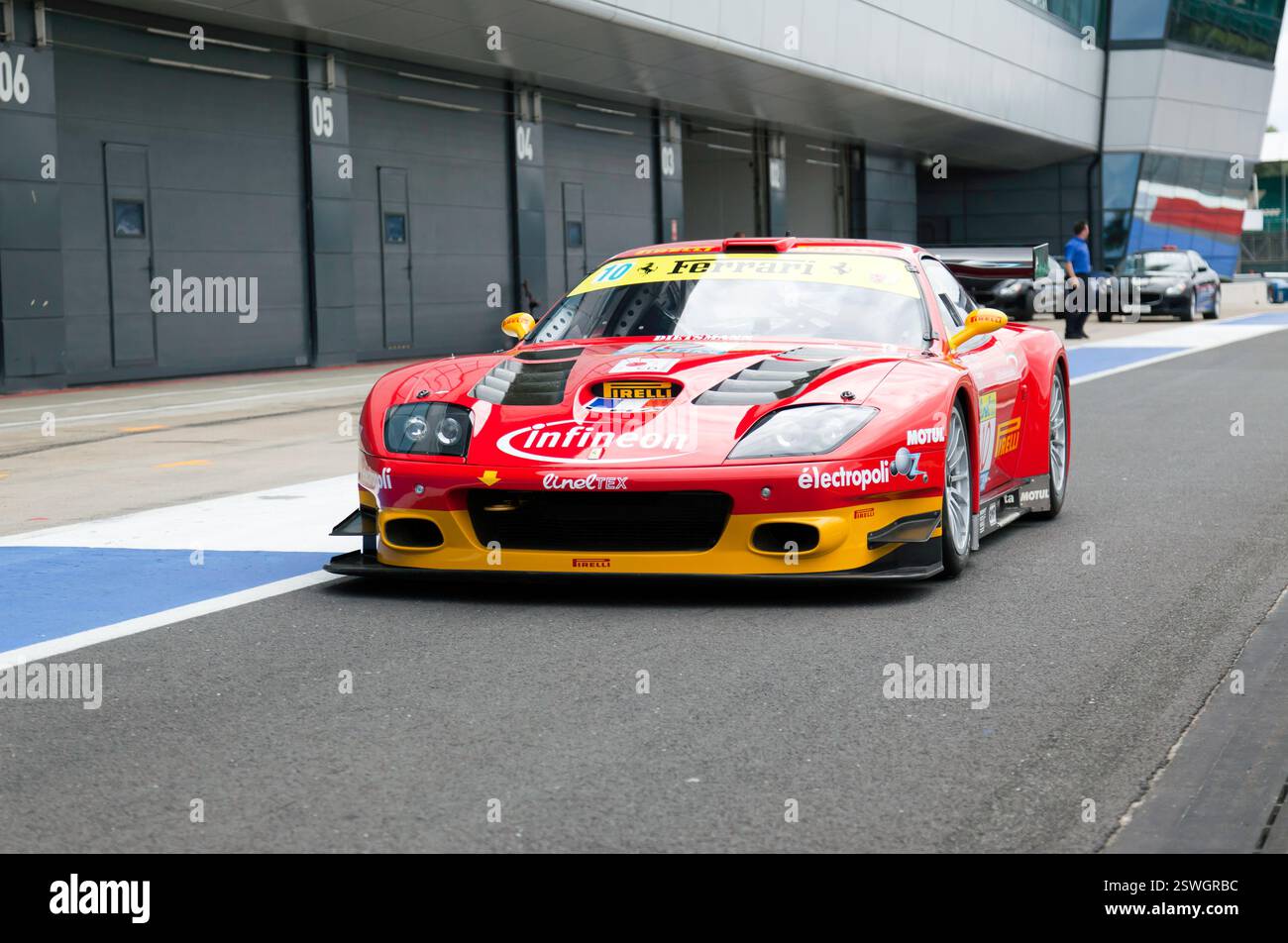 Front view of a 2002, Ferrari 575 GTC Evo race car in the International Pit lane for the 90s Endurance Legends demonstration; 2016 Silverstone Classic Stock Photo