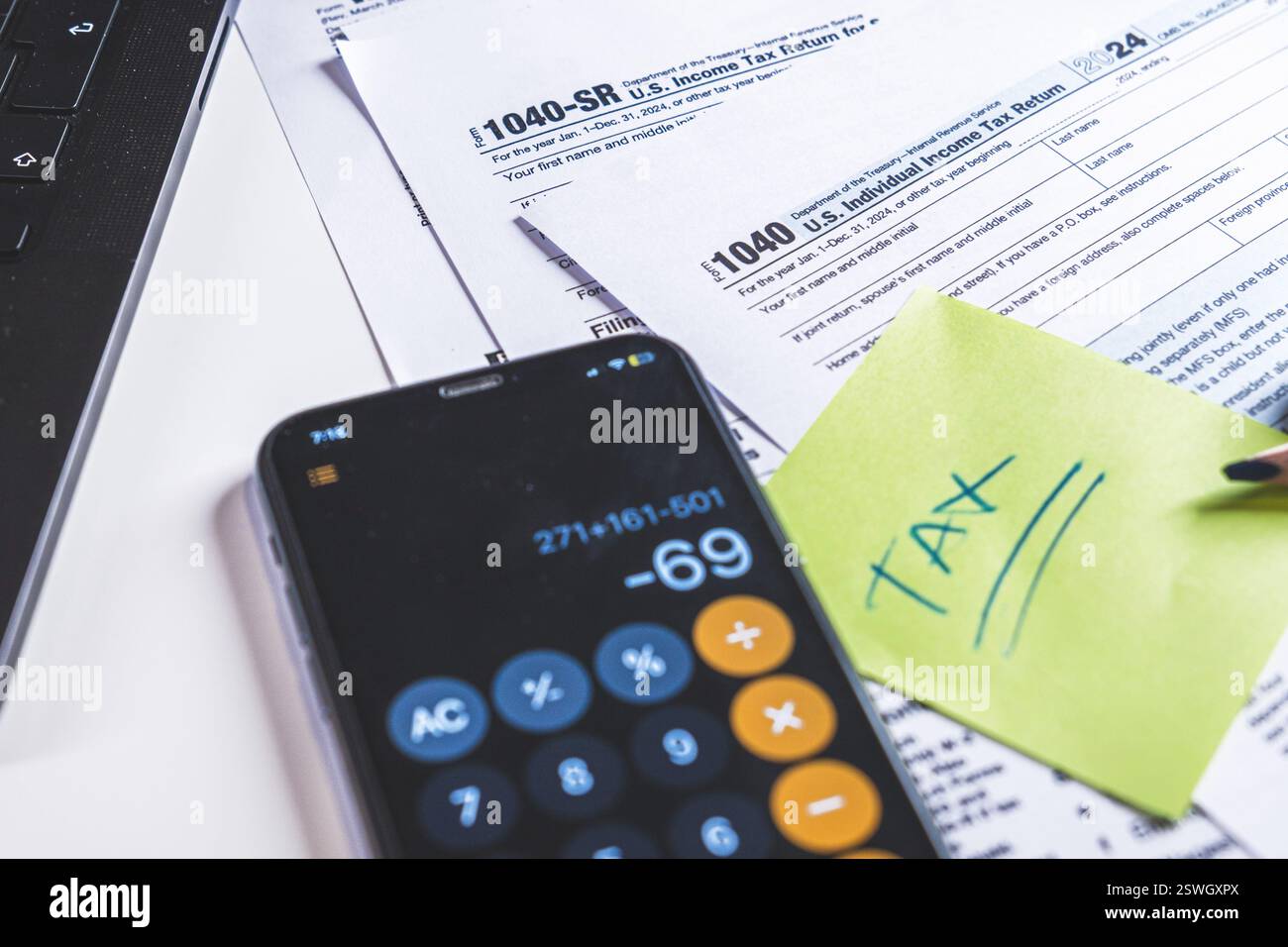 Accountant calculating taxes using calculator app on smartphone Stock Photo