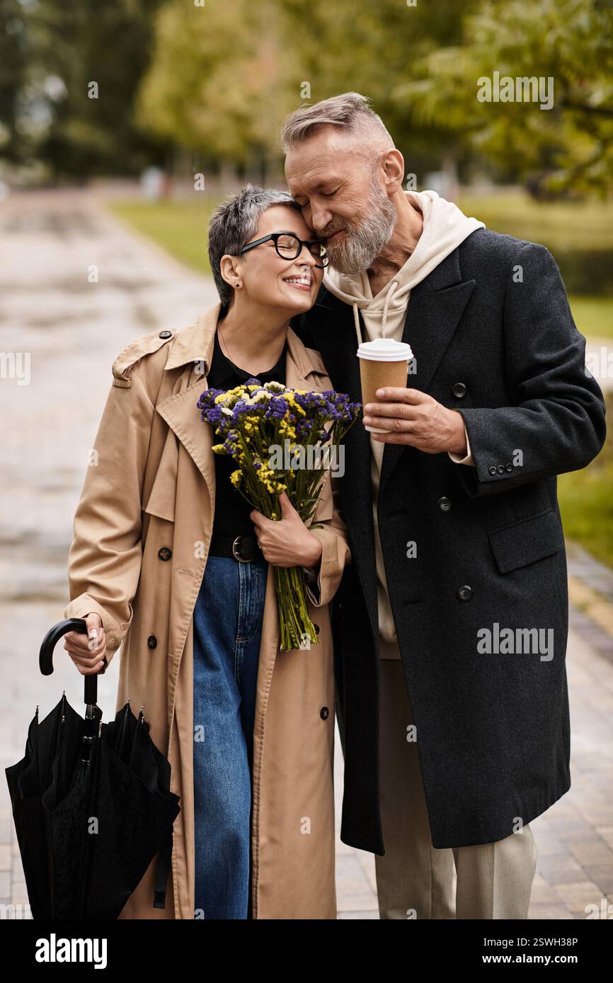 In a lovely park setting, a mature couple enjoys each others company while sharing a warm embrace. Stock Photo