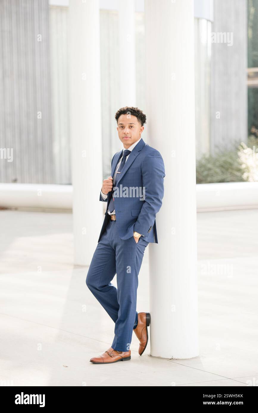 Business professional leaning against column Stock Photo