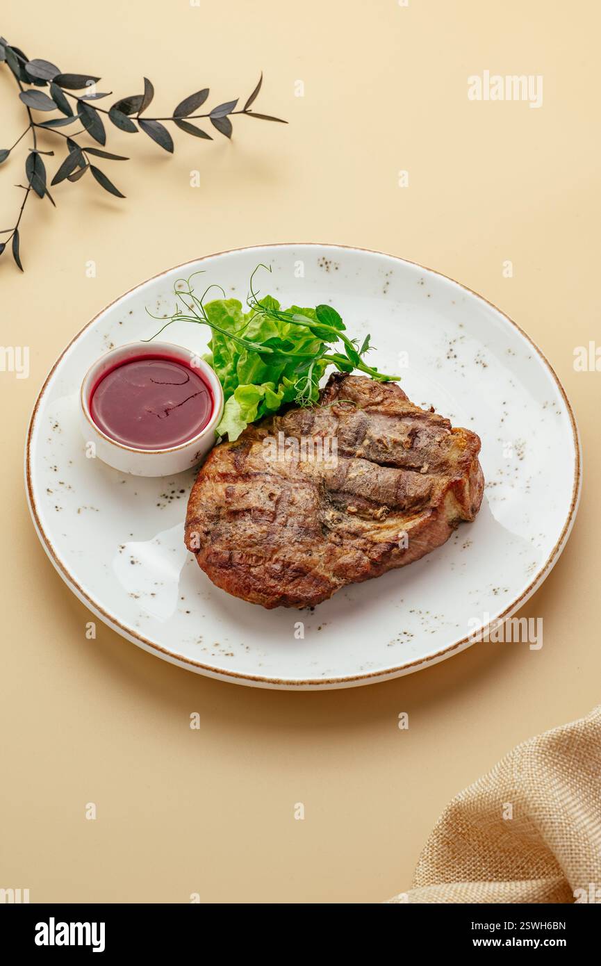 steak with lingonberry sauce and herbs Stock Photo