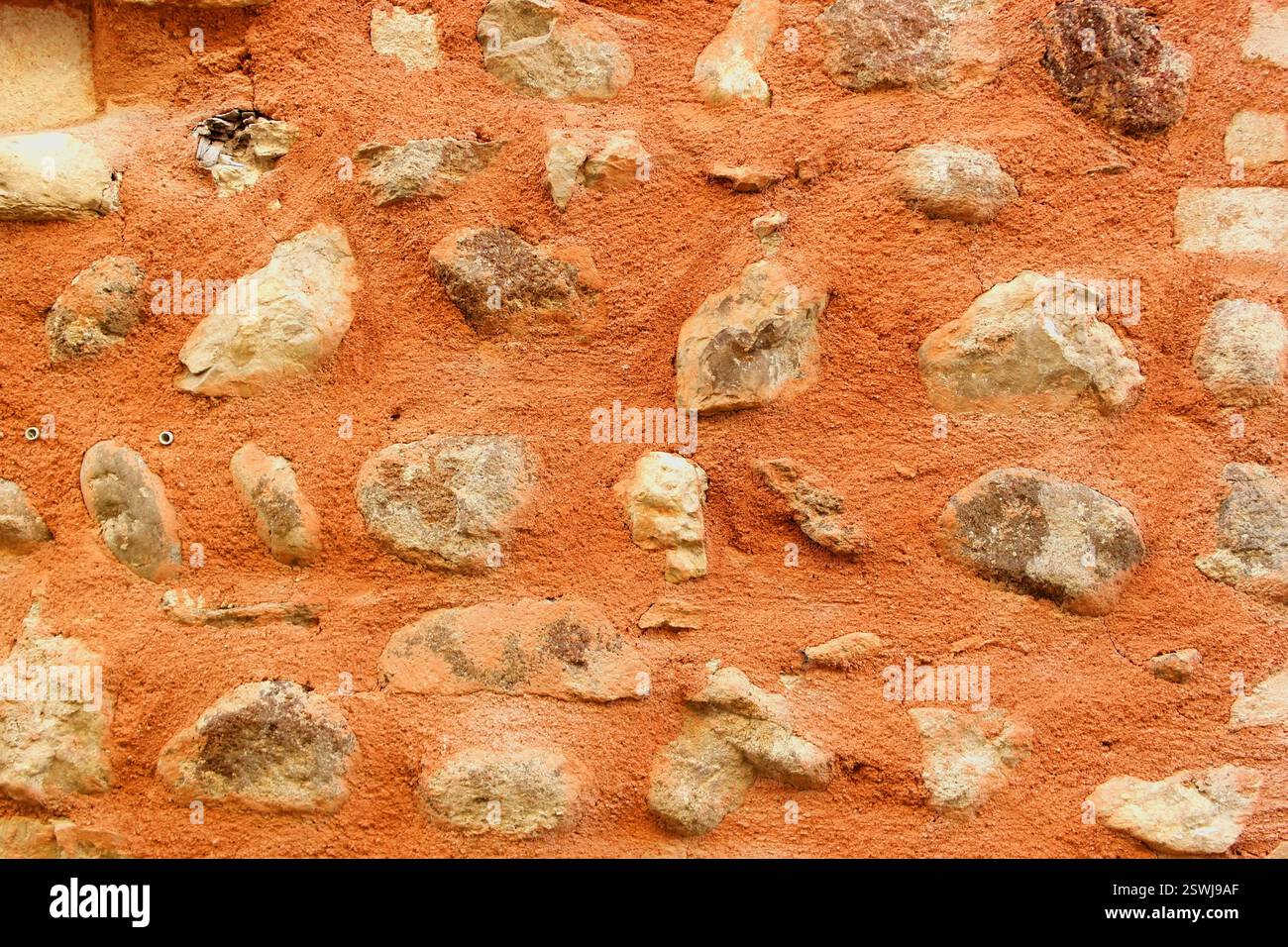 Background with red wall and big stones Stock Photo