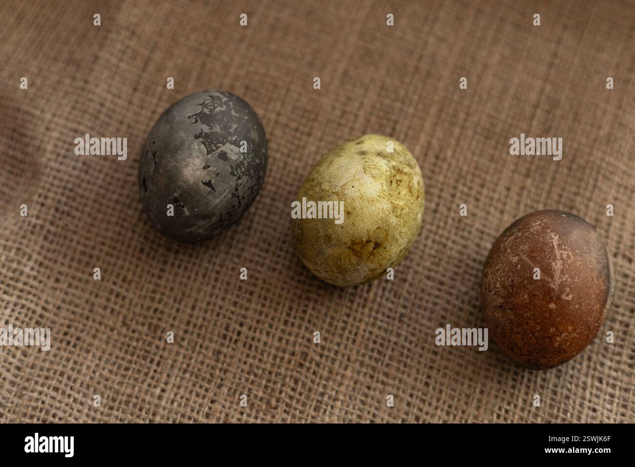 three easter eggs on a burlap texture background Stock Photo