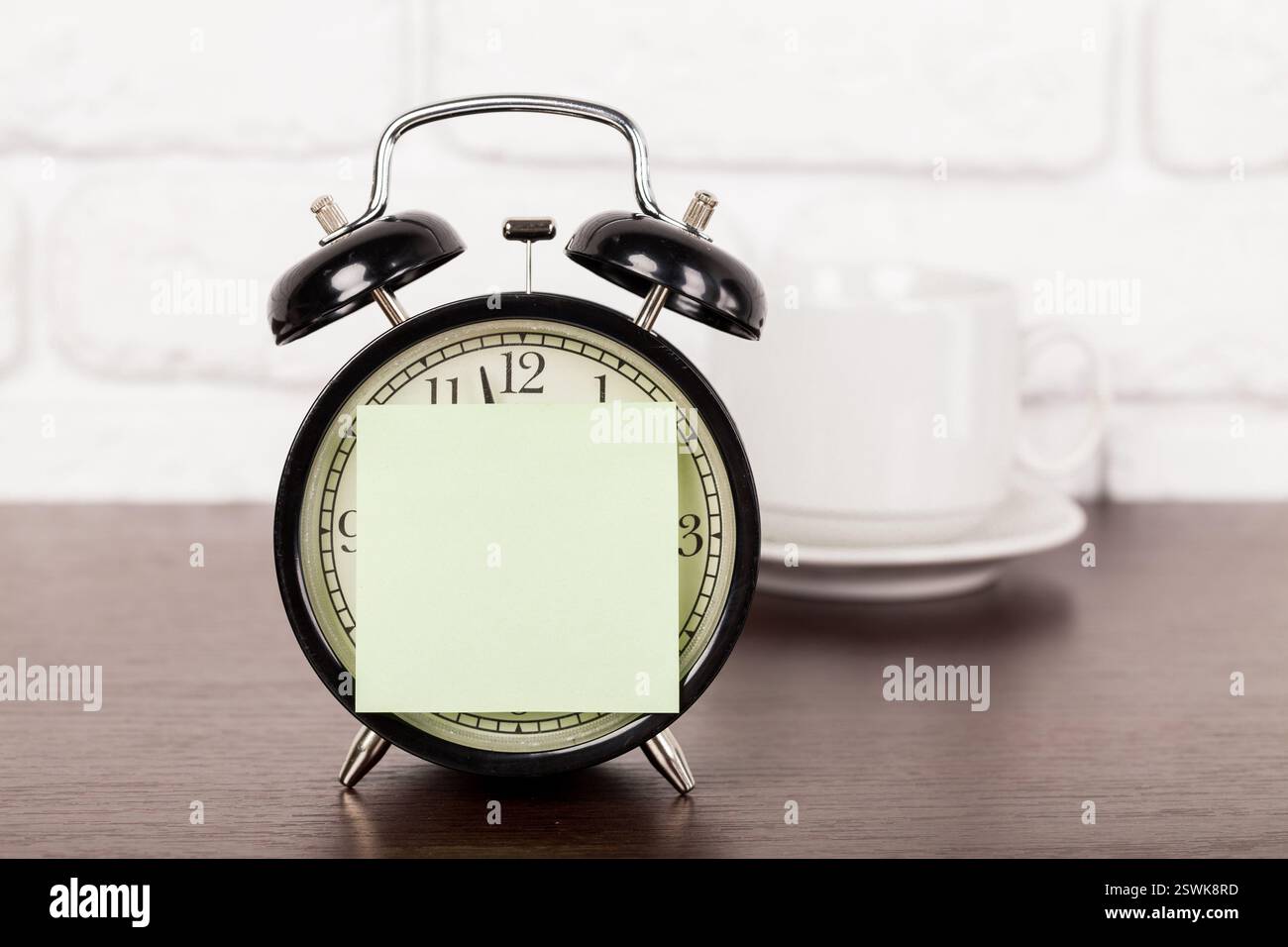 Reminder note and black old-fashioned alarm clock Stock Photo