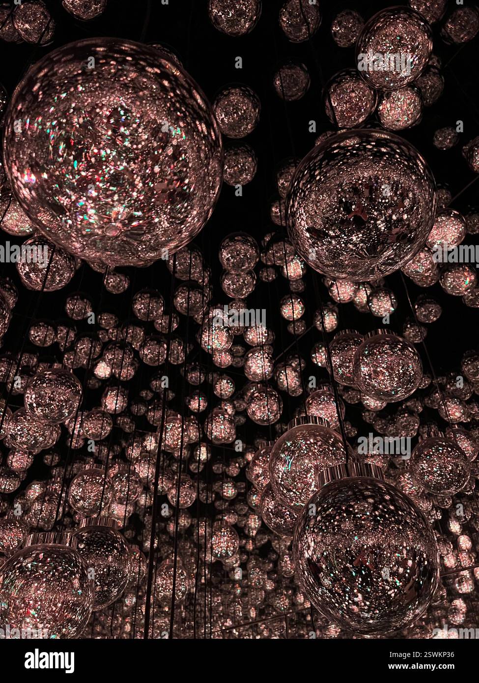 TeamLab Borderless art installation purple light bulbs room warm colors light bulbs hanging from the ceiling dark beautiful modern art | Tokyo Japan - Smartphone Captured Stock Image