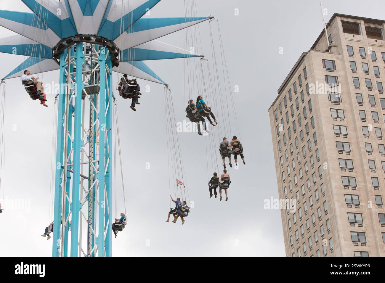 People enjoy a swing ride at the London Eye, with the prominent ...