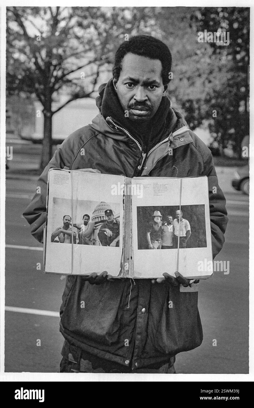 A homeless man in Washington DC shows a photo of himself at a younger age in a book. Stock Photo