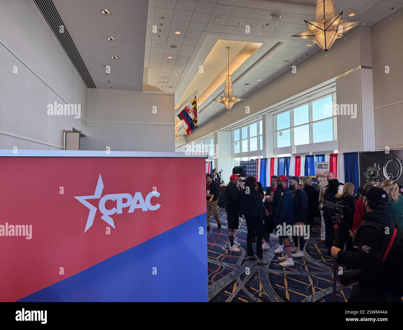 National Harbor, USA. 21st Feb, 2025. Visitors walk across the corridor ...