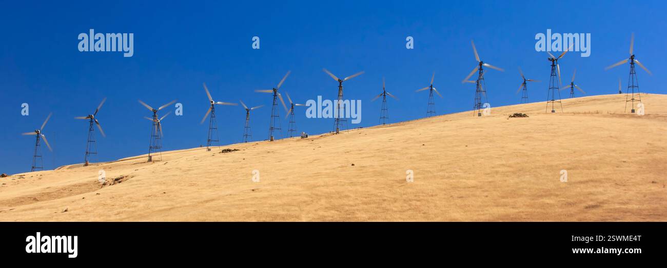 Long line of wind turbines are standing on a hill, harnessing the power ...