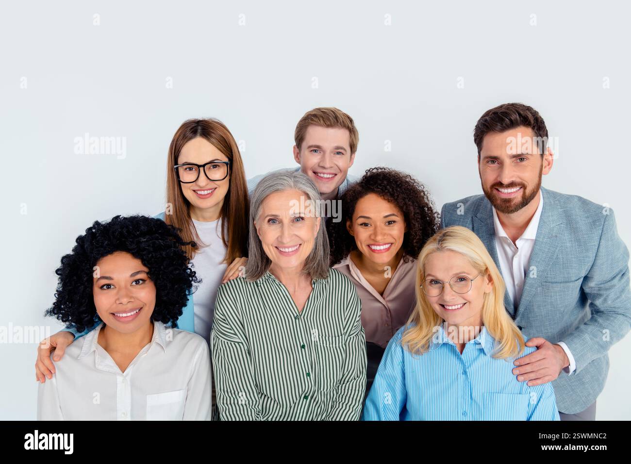 Diverse business group teamwork concept featuring coworkers in formalwear against grey background Stock Photo