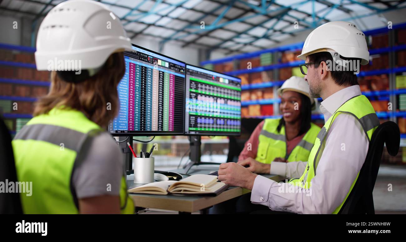 Managers Monitor Inventory Levels on Desktop Computers in Warehouse ...