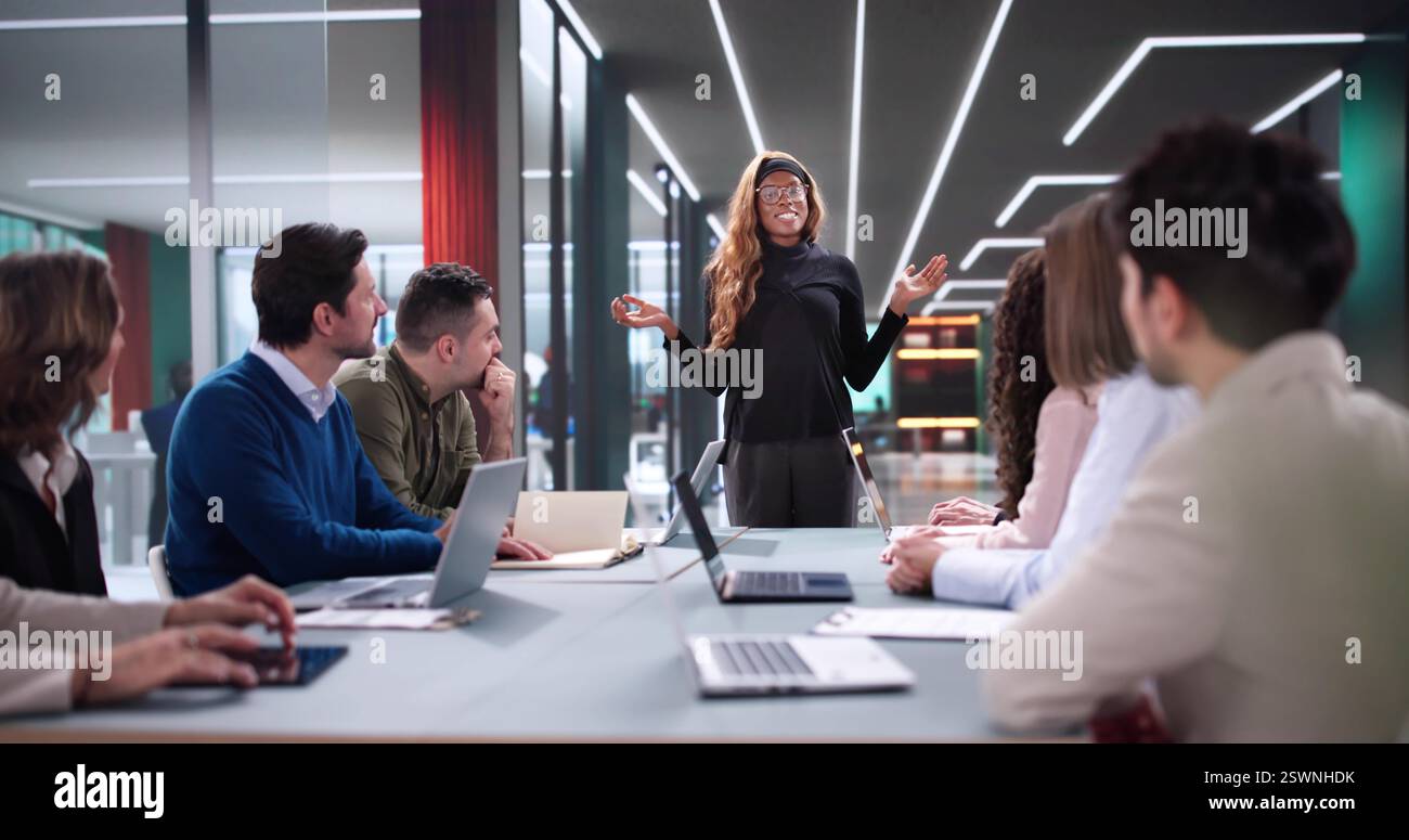 Manager leading interactive workshop for diverse group of professionals. Stock Photo
