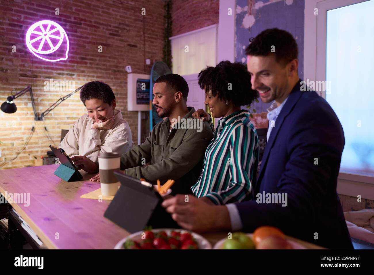 Coworkers using digital tablets, working late in modern office Stock Photo