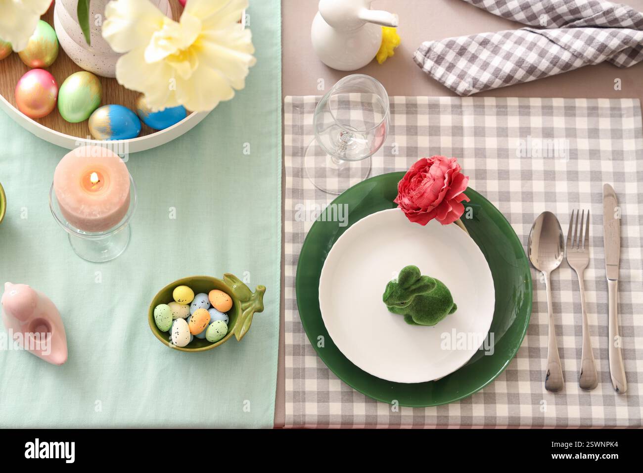 Easter table setting with flowers, painted eggs and Easter bunny Stock Photo