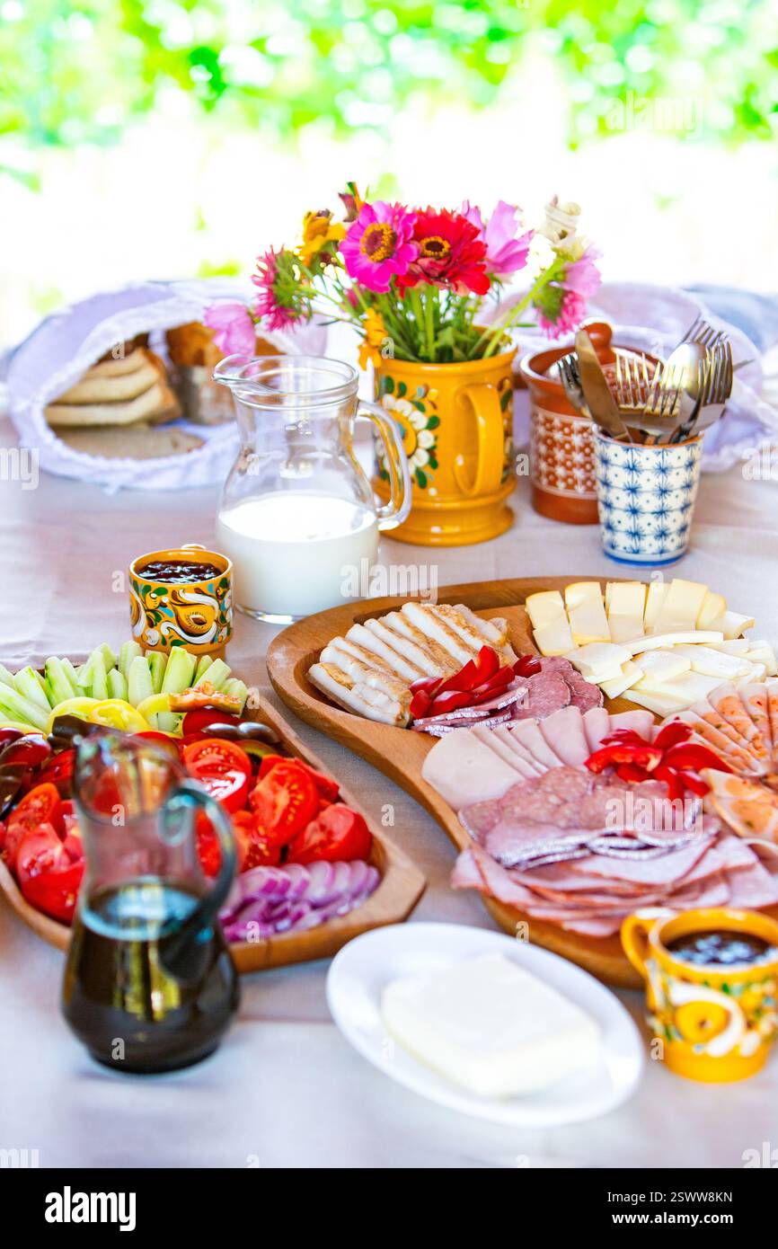 A vibrant table setting featuring breakfast dishes, fresh flowers, and colorful decorations. Stock Photo