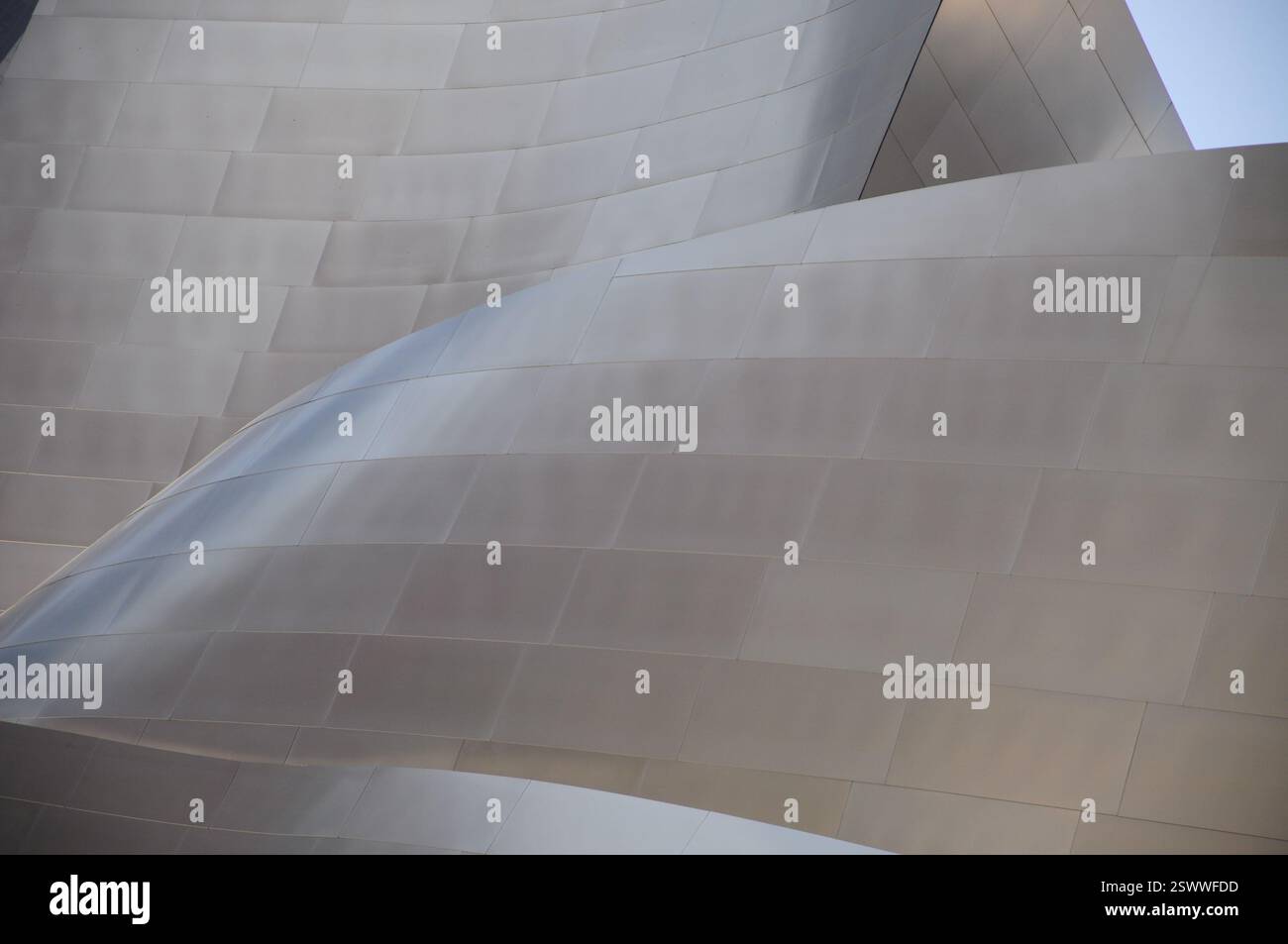 Modern architecture with curving metallic surfaces reflecting sunlight Stock Photo