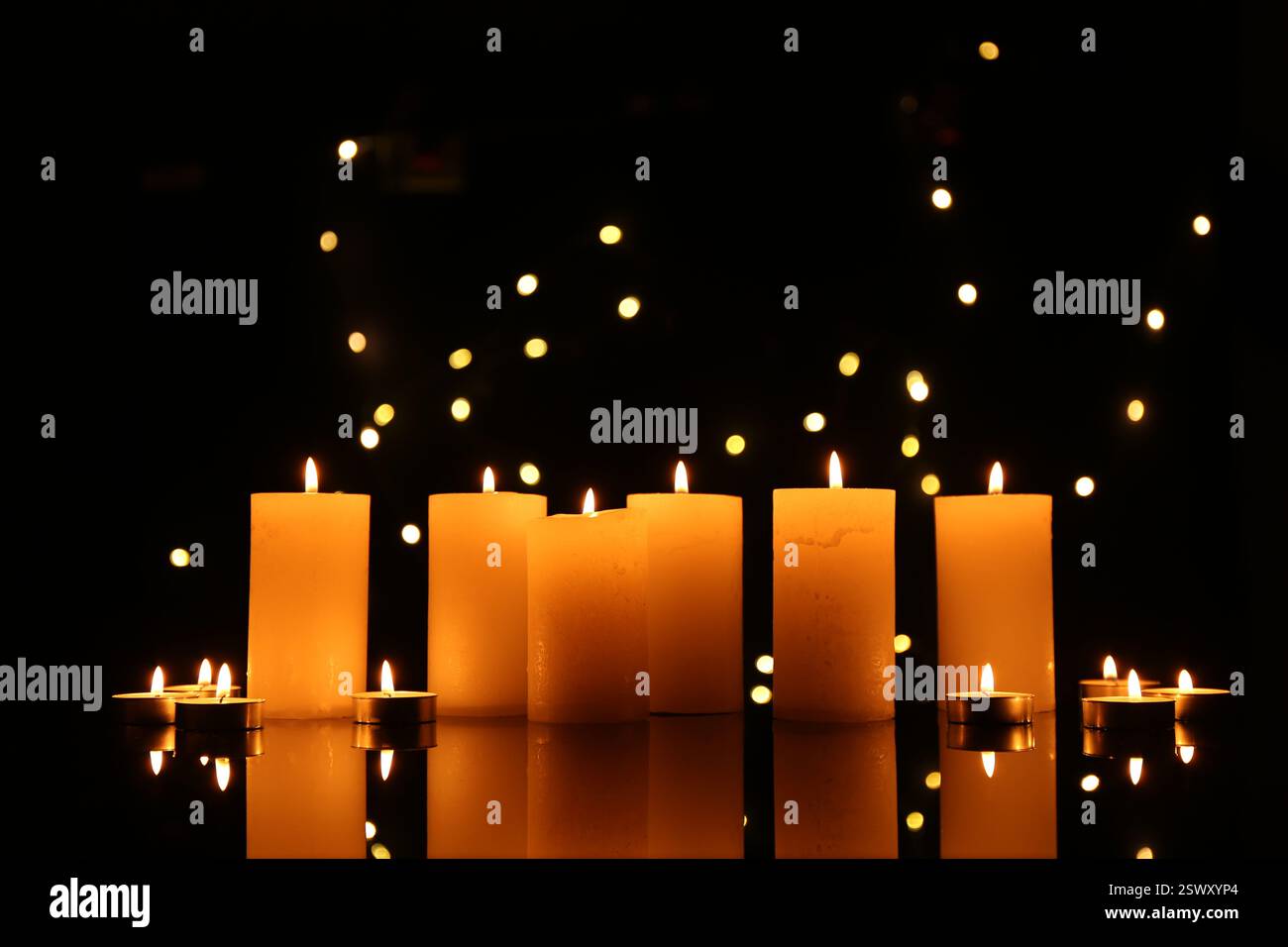 Many burning candles on mirror surface in darkness Stock Photo - Alamy
