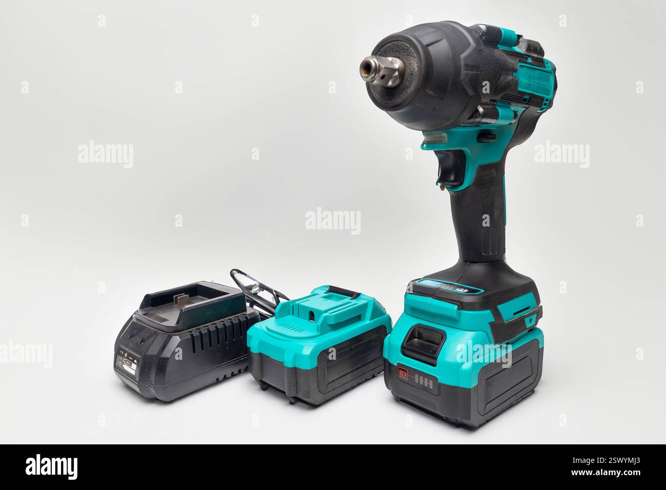 Professional impact wrench with battery and charger isolated on transparent background, essential tools for mechanics and construction workers Stock Photo