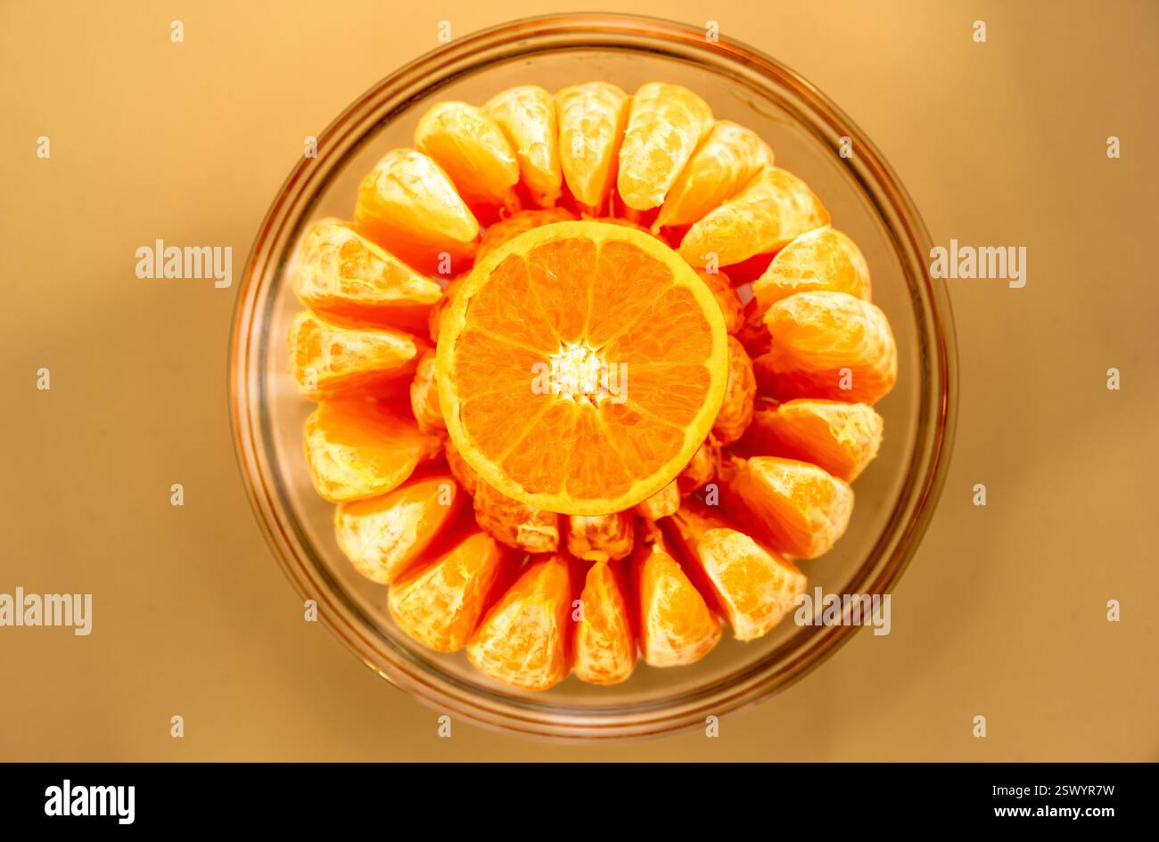 Top-Down View of a Sliced Orange and Peeled Mandarin Segments Arranged in a Glass Bowl, Showcasing Vibrant Citrus Textures and Symmetry Stock Photo