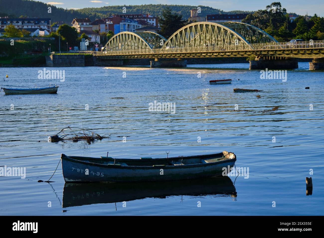 Tranquil river scene with arched bridge and boats Stock Photo