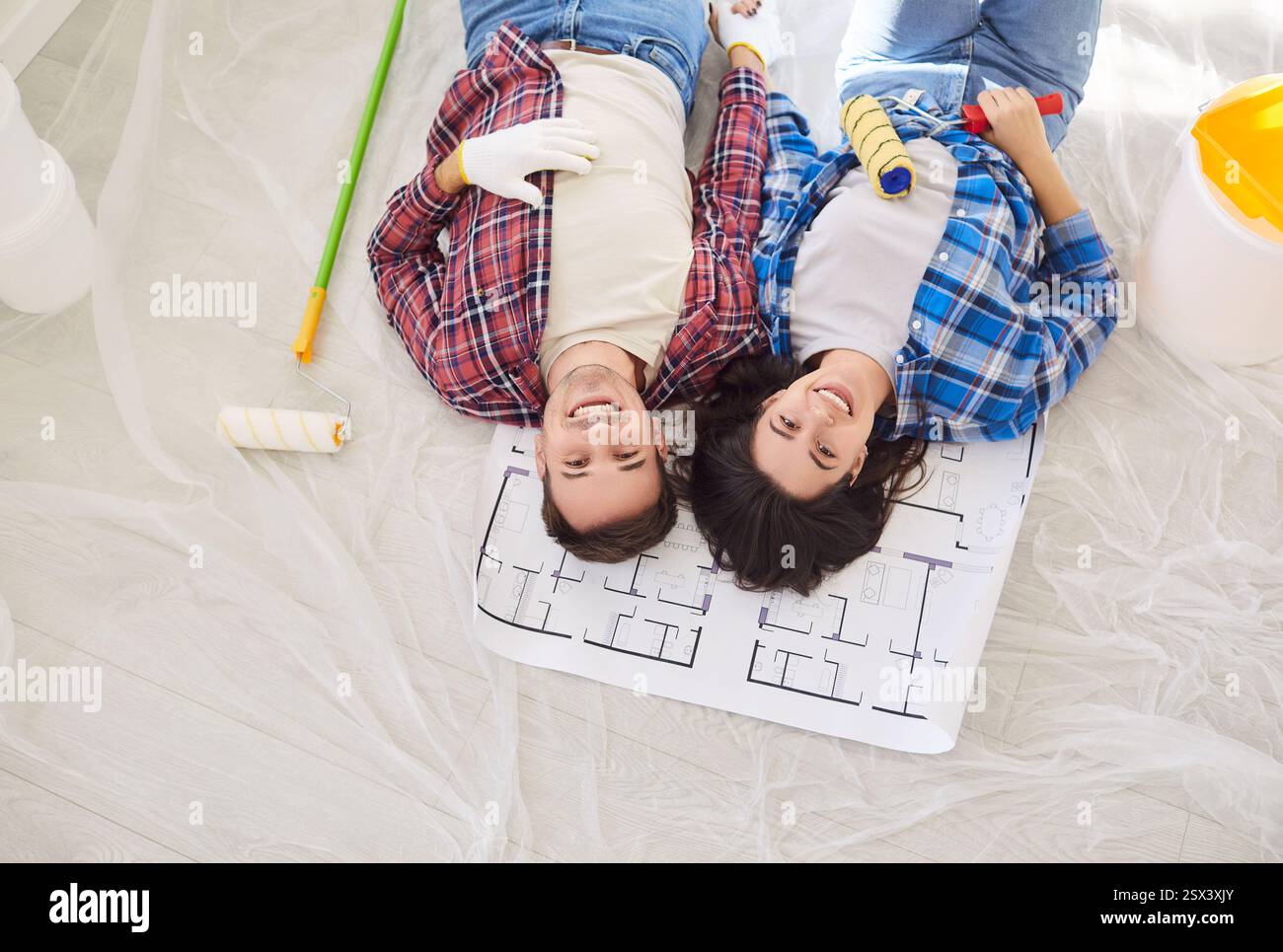 Picture of Happy Family Couple Lying Together During Home Renovation Stock Photo ...