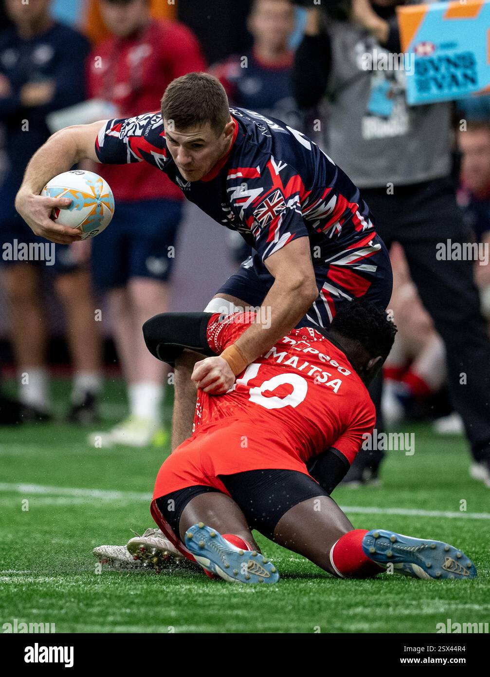 Great Britain's Charlton Kerr, back, is tackled by Kenya's Nygel ...