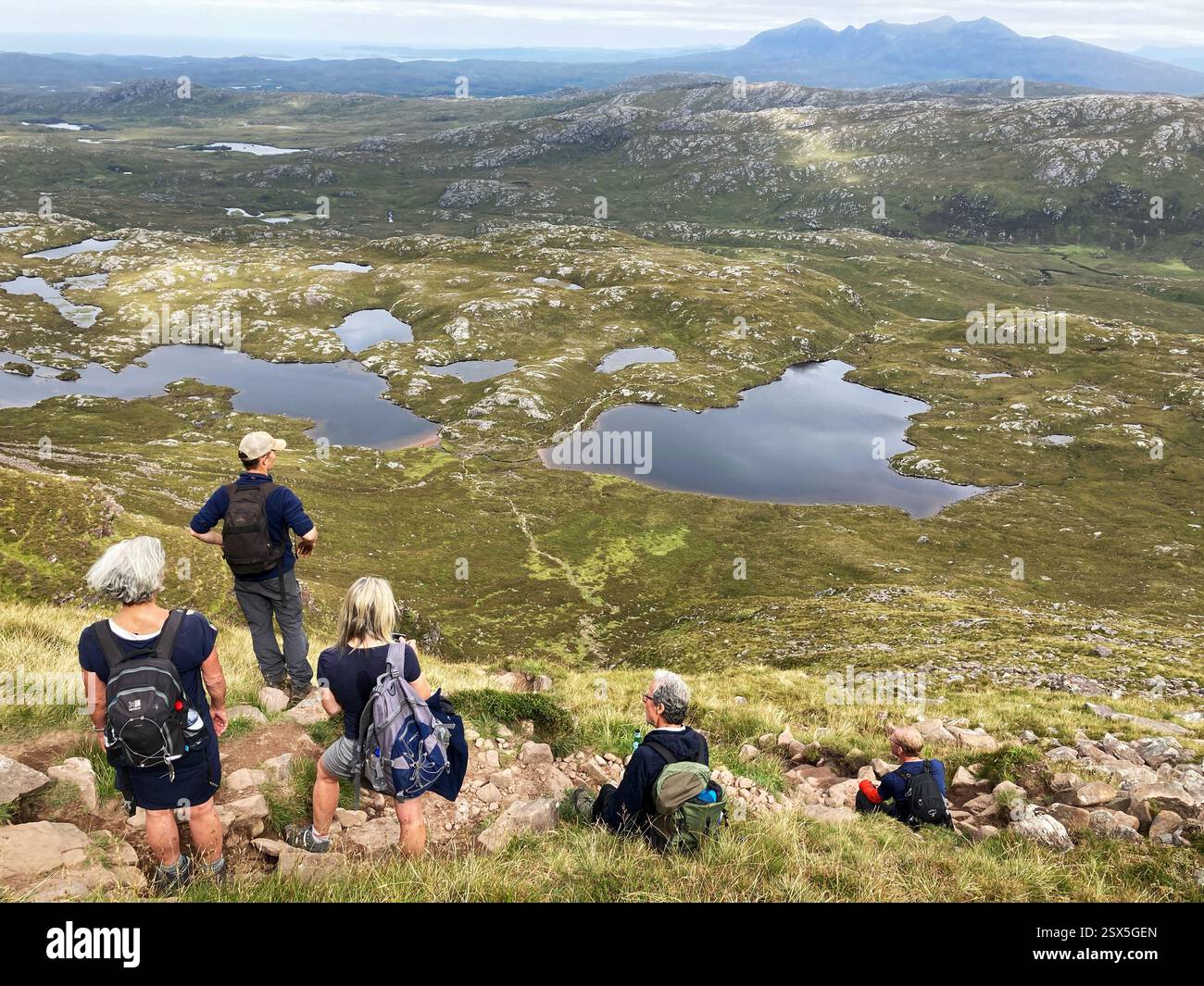 Hikers on the ascent of the iconic Scottish mountain Suilven looking north, Inverpolly Sutherland, Scotland - Smartphone Captured Stock Image