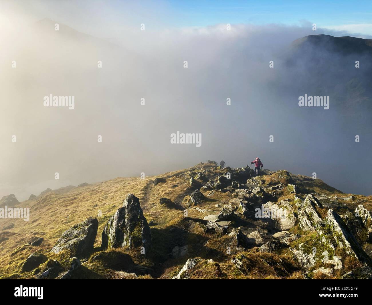 Hiker on the path up towards the summit of munro Ben Lawers with a cloud inversion filling the glen, Scotland - Smartphone Captured Stock Image