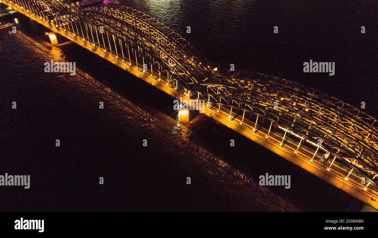 Night city aerial view of Cologne in Germany from above showing famous river Rhein and bridge Hohenzollernbrücke with night lightening Stock Photo