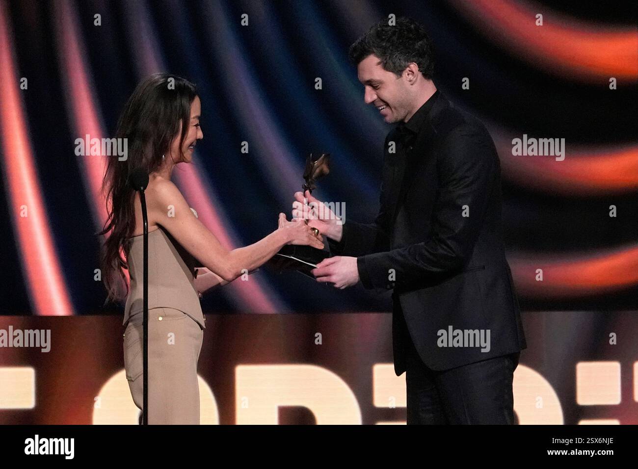 Michelle Yeoh, left, presents Alex Coco with the award for best feature ...