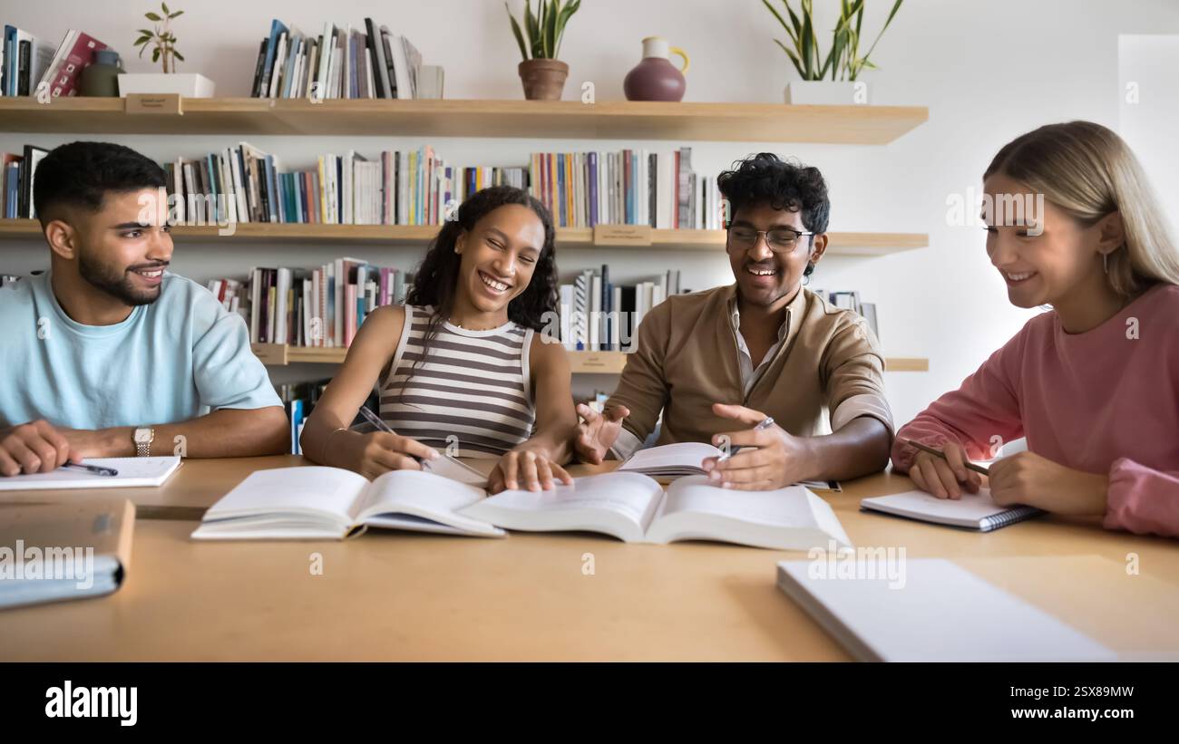 Happy multiethnic students studying together in library Stock Photo
